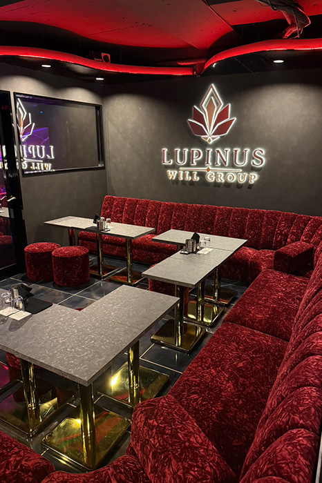LUPINUSのロゴとボルドーのソファがある店内